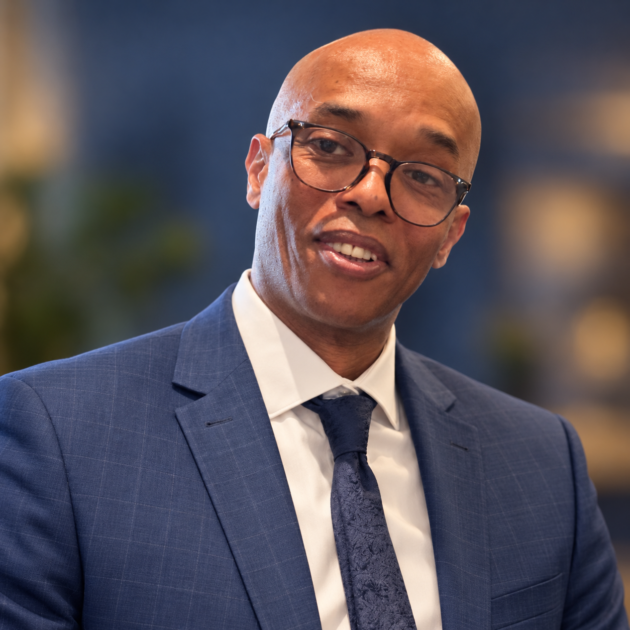 Ray Brown wearing glasses and a blue suit.
